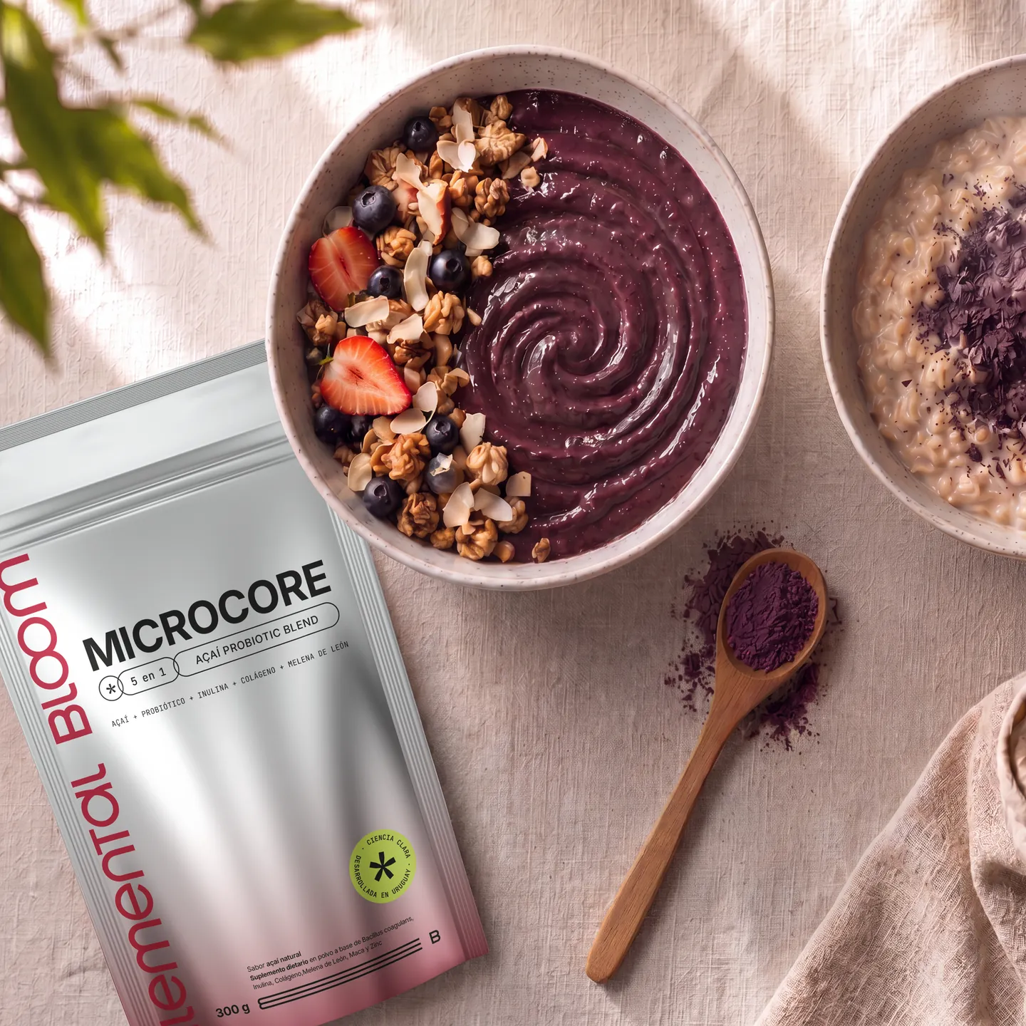 Bowl de açaí con granola junto al pouch de MICROCORE, un bowl de avena y açaí en polvo